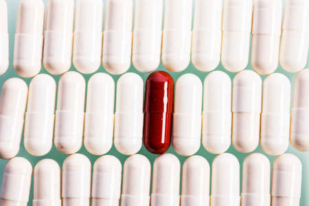 White capsules and one red in line. Studio shotの写真素材
