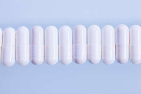 White capsules and one red in line. Studio shot