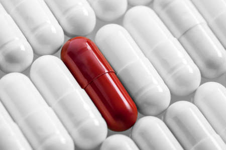 White capsules and one red in line. Studio shotの写真素材