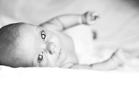 Beautiful baby girl on white blanket. Studio shotの写真素材