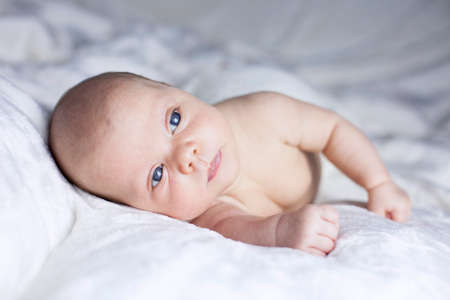 Beautiful baby girl on white blanket. Studio shotの写真素材