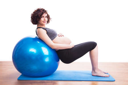 Young pregnant woman exercises with the ball.の写真素材