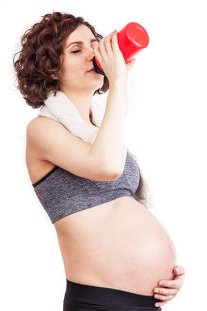 Young pregnant woman practicing fitness. Isolated on white backgroundの写真素材