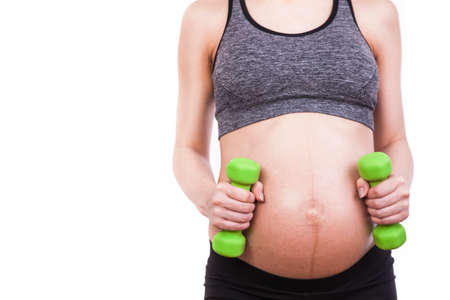 Young pregnant woman practicing fitness. Isolated on white backgroundの写真素材
