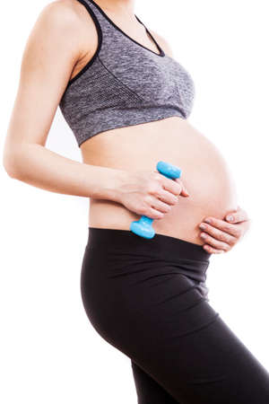 Young pregnant woman practicing fitness. Isolated on white backgroundの写真素材