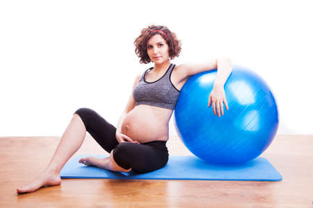 Young pregnant woman exercises with the ball.の写真素材