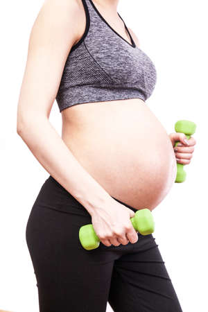 Young pregnant woman practicing fitness. Isolated on white backgroundの写真素材