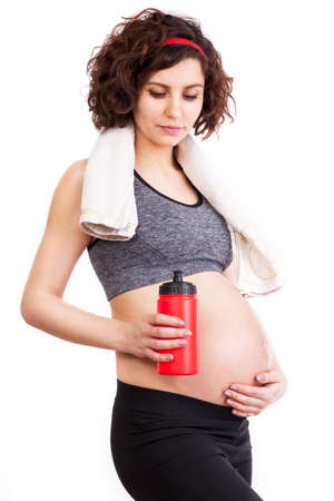 Young pregnant woman practicing fitness. Isolated on white backgroundの写真素材