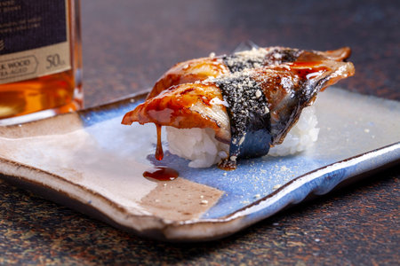 Sushi roll with eel and soy sauce on a plate.の写真素材