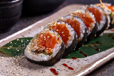 Sushi roll with salmon, avocado, cucumber, cheese and sesame seeds.の写真素材