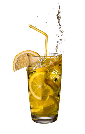 Splash drops from a transparent glass cup with lemonade, lemon slices, ice and a yellow straw. isolated on white backgroundの写真素材