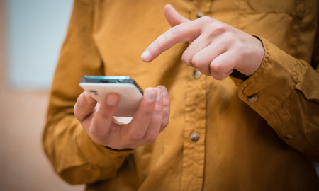 Close up of a man using mobile smart phone