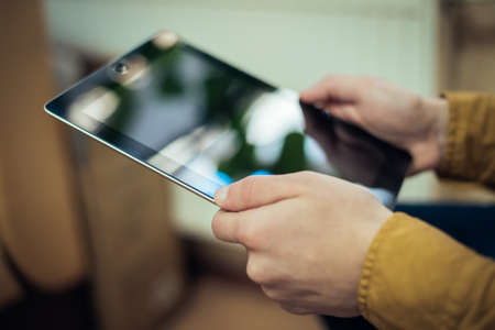Close up of male hand using digital tabletの写真素材