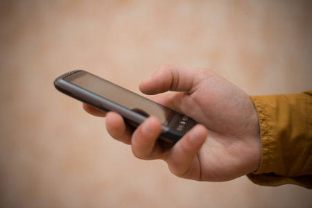 Close up of a man using mobile smart phoneの写真素材