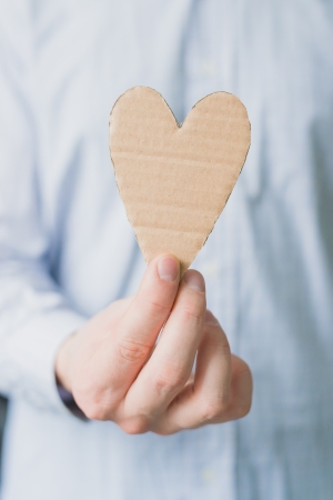 A man holds a heart in his handの写真素材