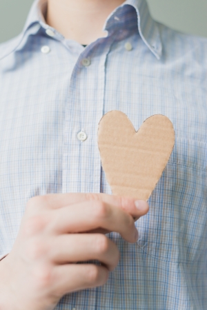 A man holds a heart in his handの写真素材