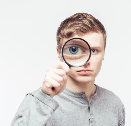 Man looking through a magnifying glassの写真素材