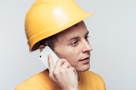 Male worker talking on mobile phoneの写真素材