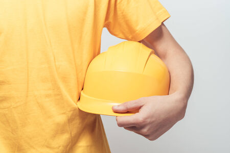 Male worker holding yellow helmet