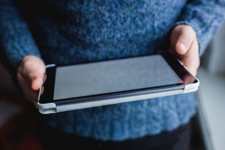 The man uses a tablet PC. Modern gadget in hand.