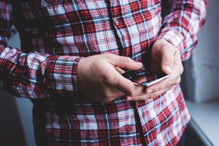 The man is using a smartphone. Modern mobile phone in hand.の写真素材