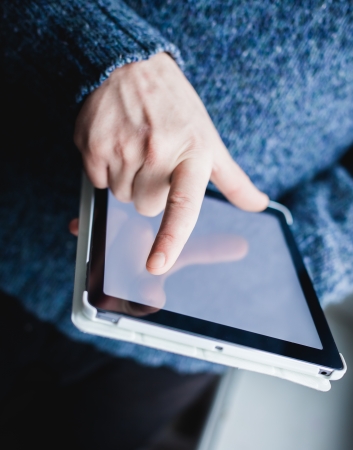 The man uses a tablet PC. Modern gadget in hand.の写真素材