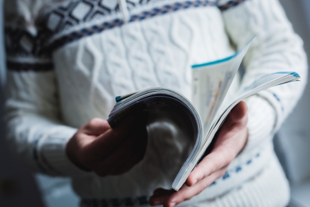 A man looks at a magazine. Press hands.の写真素材