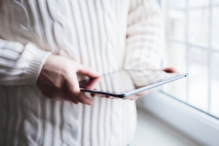 The man uses a tablet PC. Modern gadget in hand.