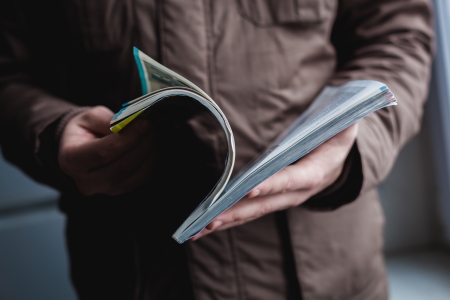 A man looks at a magazine. Press hands.の写真素材