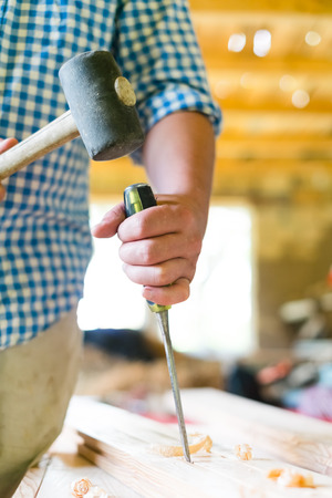 gouge wood chisel carpenter tool hammer in hand working wooden backgroundの写真素材