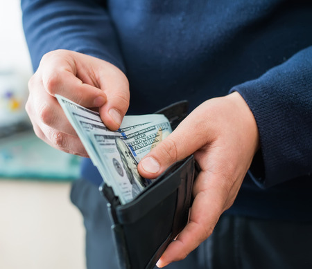 Purse with dollars in their hands.の写真素材