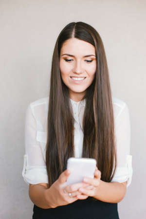 young girl looking at phone and smilingの写真素材