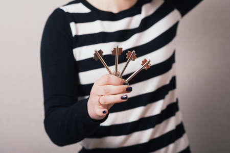 Woman hand holding keys on Gray backgroundの写真素材