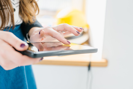 Young woman uses tablet while relaxing at home