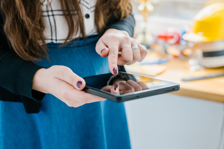Young woman uses tablet while relaxing at homeの写真素材