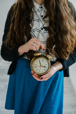 Young woman with alarmclock at the morningの写真素材