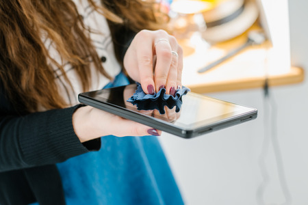 woman hands cleaning a tablet with a napkin