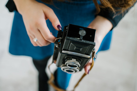 Portrait of a pretty young woman taking photographs with vintage retro cameraの写真素材