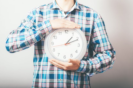 Businessman holding large clock