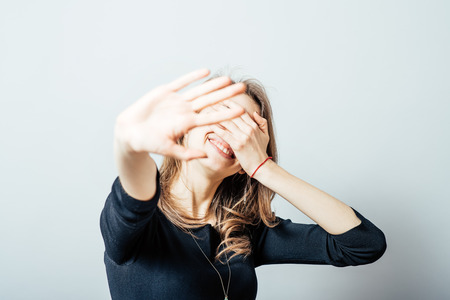 young woman laughing covering his faceの写真素材