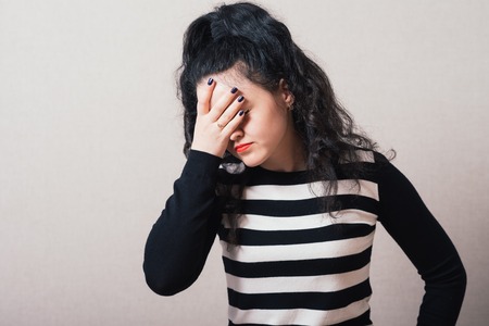 The woman closed her eyes. Gray background.の写真素材