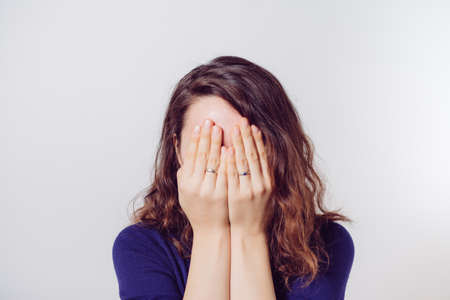 Woman covers his face by handの写真素材