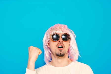 Funny nerdy guy in goggles and a wig.の写真素材