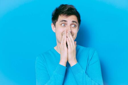 man laughs and covers her mouthの写真素材