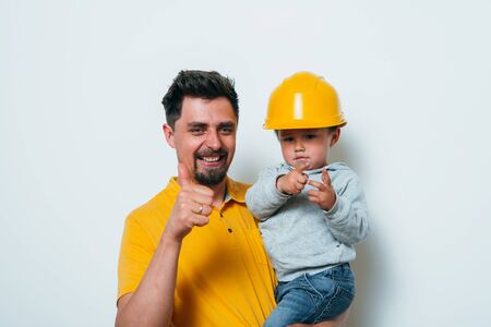 Little boy on his hands in a construction helmetの写真素材