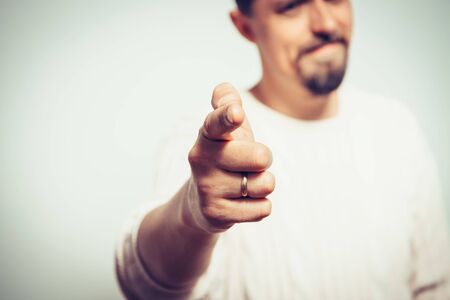 Young man showing his index finger towards the cameraの写真素材