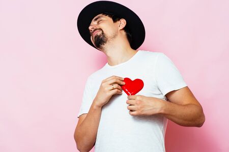 Portrait of a young man holding a large heart