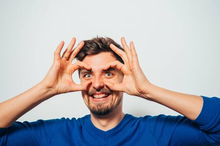 man looking through hands, making binocularsの写真素材