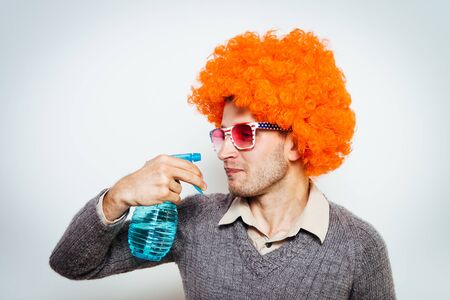 guy in a wig with a cleaner for windowsの写真素材