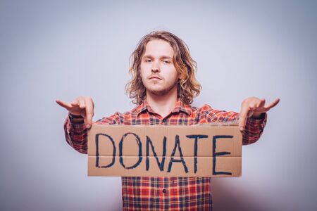 male, cardboard sign donation. On a gray backgroundの写真素材